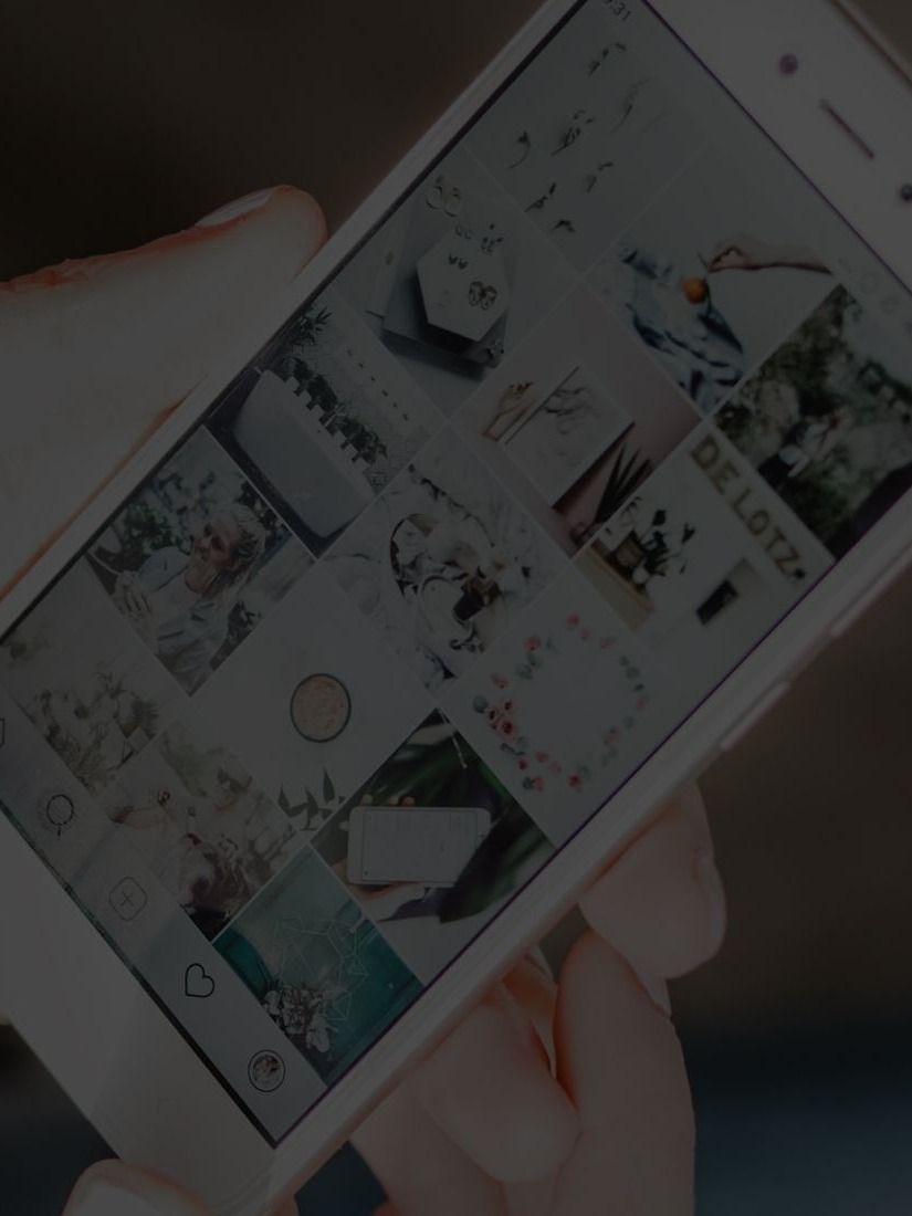 Person holding smartphone displaying Instagram feed.